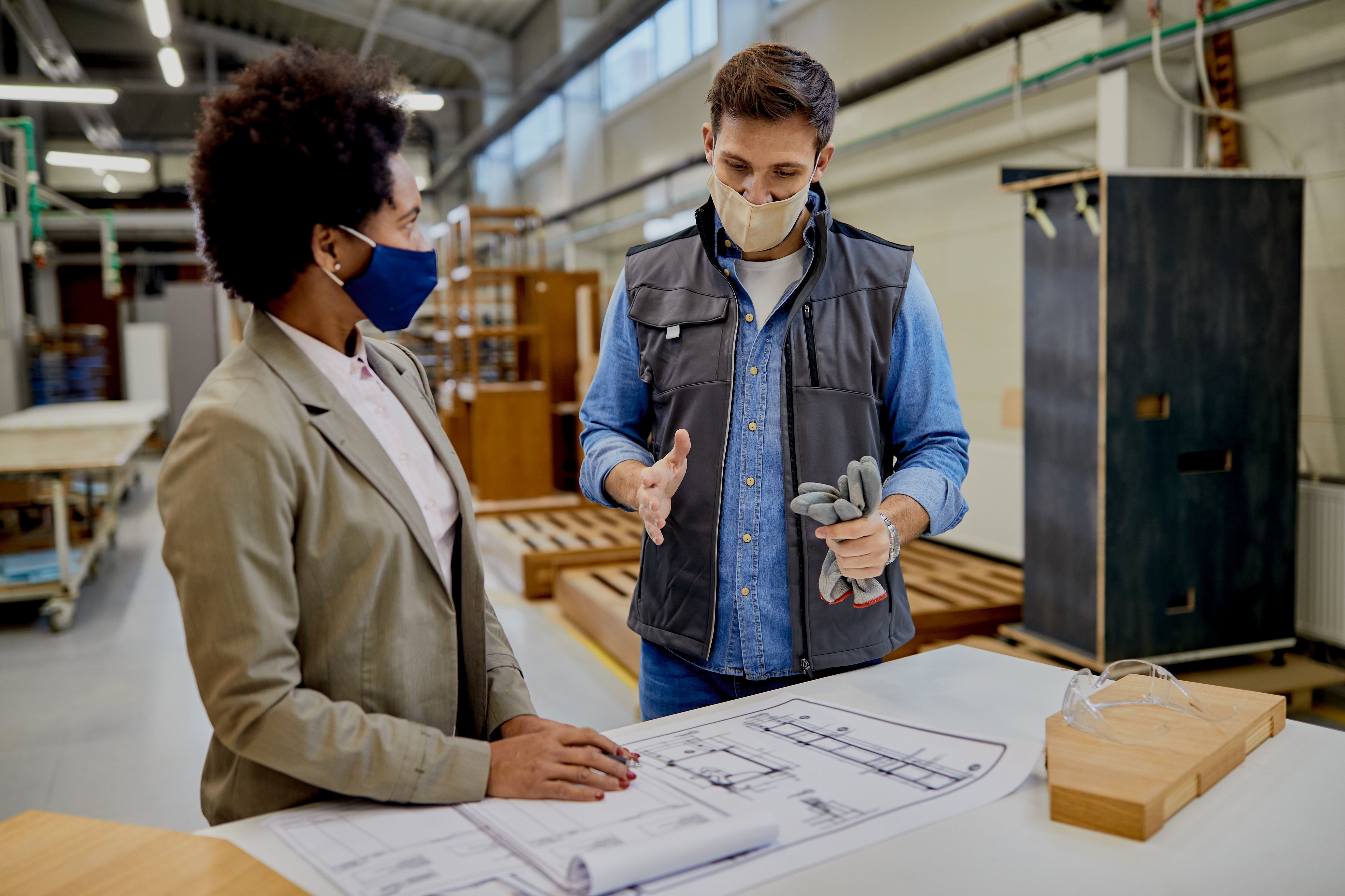 male-carpenter-explaining-design-plans-to-african-2022-09-27-22-52-33-utc.jpg